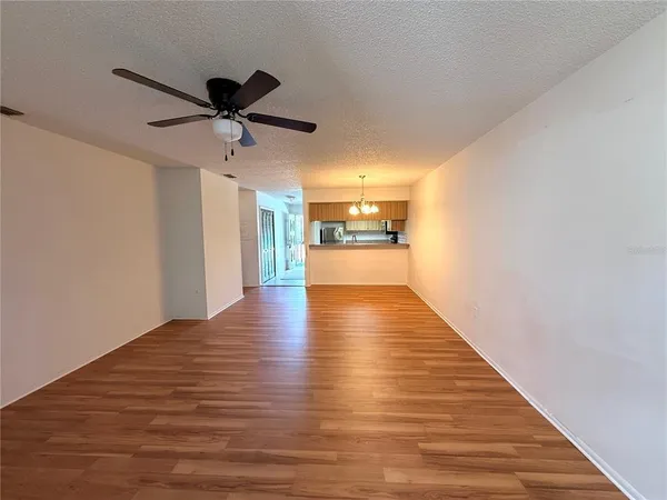 a view of a kitchen with wooden floor and a ceiling fan