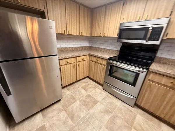 a kitchen with refrigerator and microwave