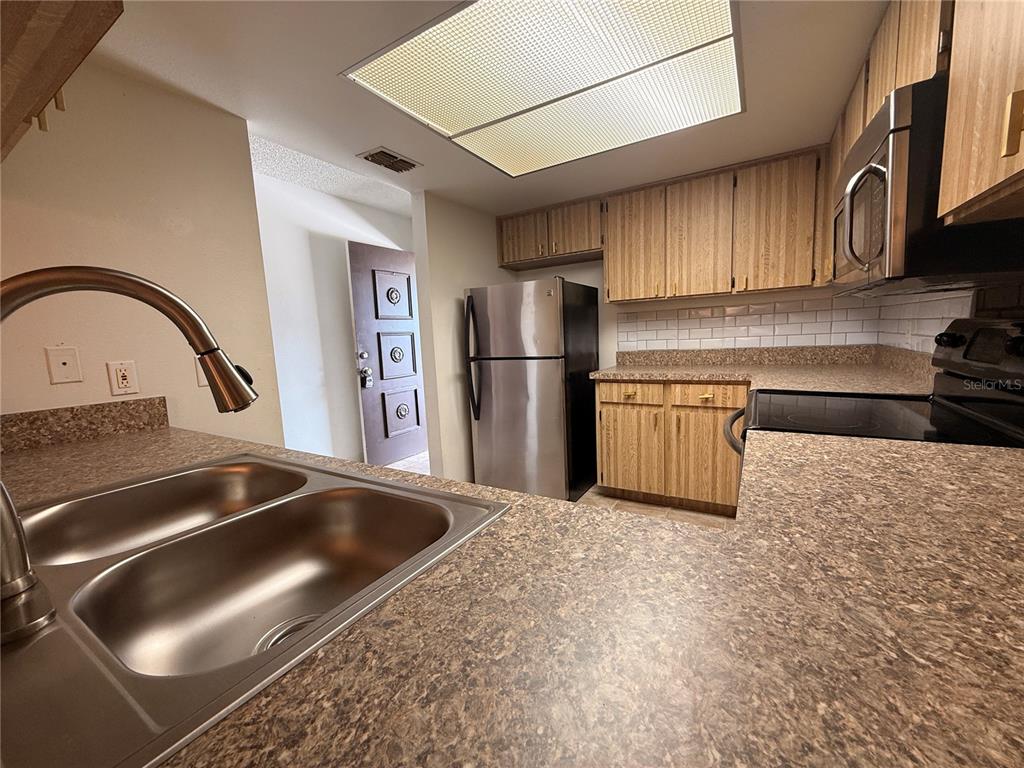 12155 Environmental Drive, Unit 6 New Port Richey, FL 34654 - Photo 10 of 42 a kitchen with a sink and a refrigerator