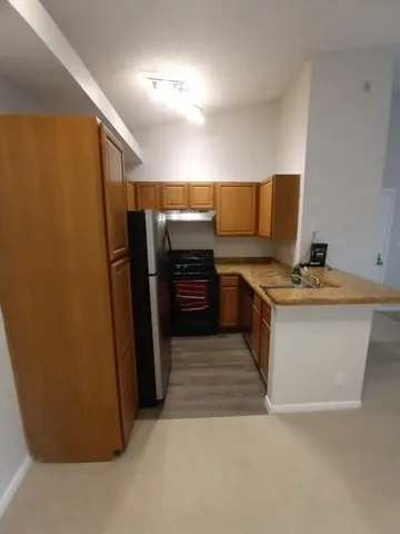 a kitchen with stainless steel appliances granite countertop a refrigerator and a stove