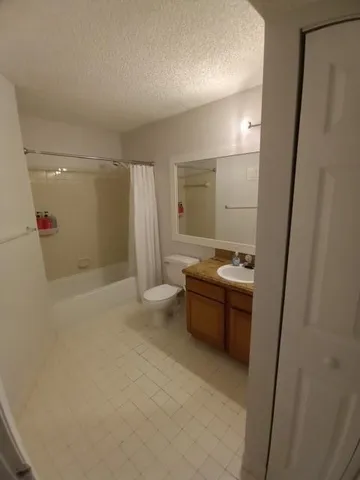 a bathroom with a tub sink shower and mirror