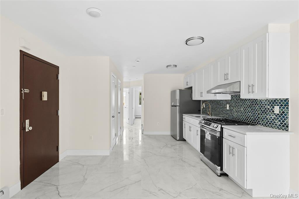 107-47 49th Avenue Queens, NY 11368 - Photo 12 of 41 a kitchen with stainless steel appliances granite countertop a stove and a refrigerator