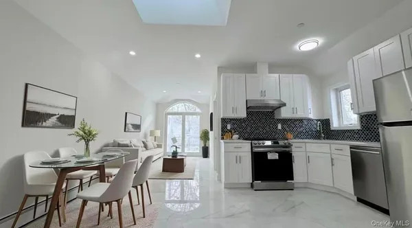 a kitchen with granite countertop white cabinets and refrigerator