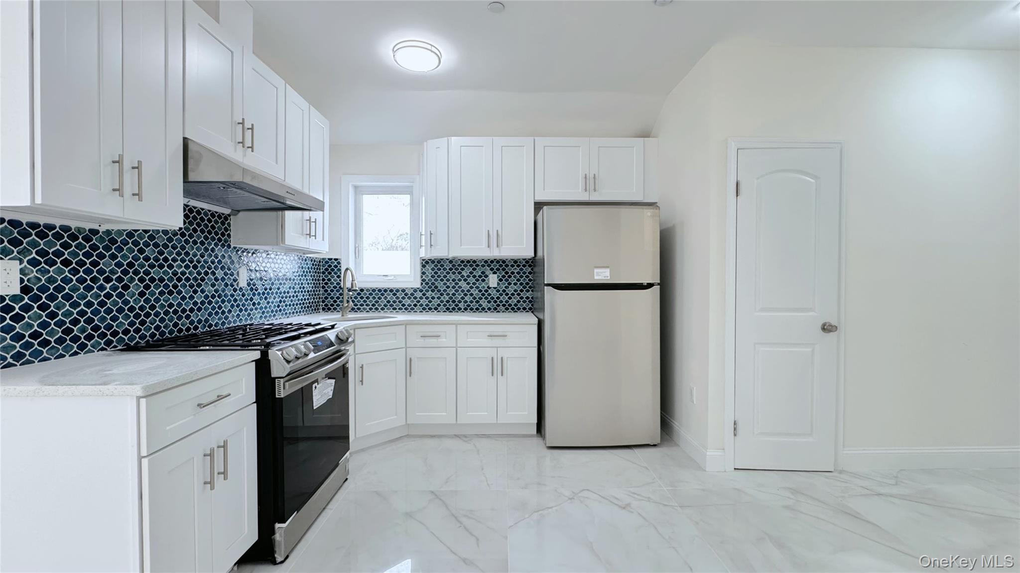 107-47 49th Avenue Queens, NY 11368 - Photo 25 of 41 a kitchen with granite countertop white cabinets and refrigerator