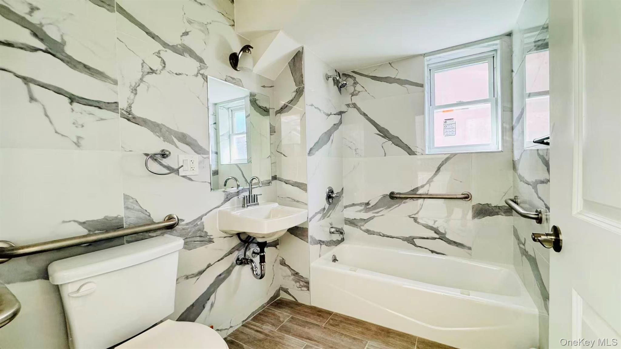 107-47 49th Avenue Queens, NY 11368 - Photo 7 of 41 a bathroom with a sink and mirror with bathtub