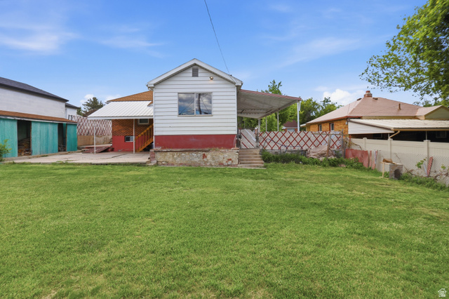 774 37th Street South Ogden, UT 84403 - Photo 27 of 47 Expansive green lawn with a white-sided structure featuring a single window and red base