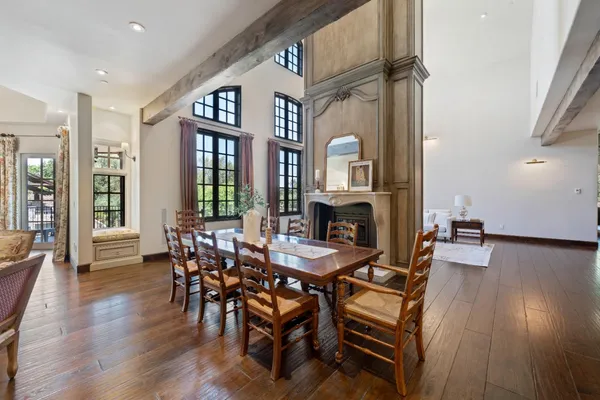 a living room with couches and kitchen view with wooden floor