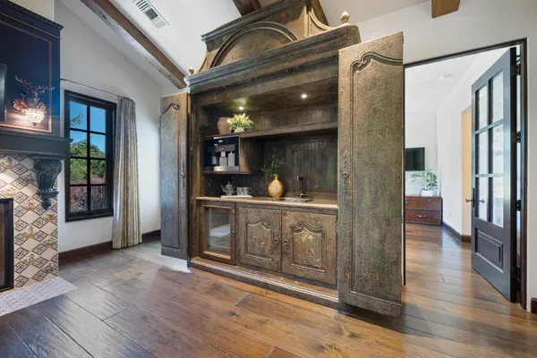 a living room with couches a table and chairs with wooden floor