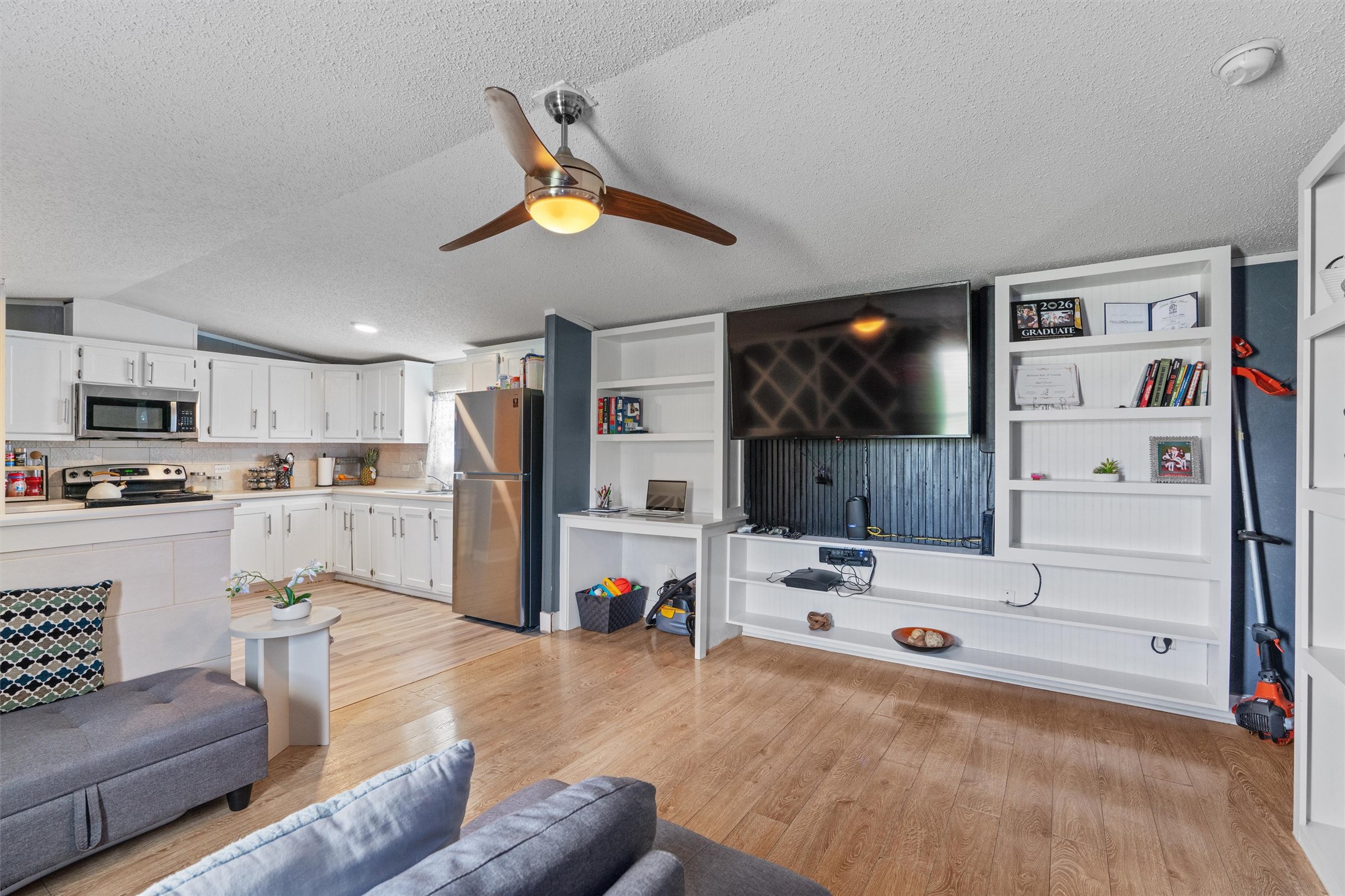 218 Boxcar Path Kyle, TX 78640 - Photo 3 of 21 An open concept living area seamlessly blends a bright kitchen with warm wooden floors, offering comfortable living.