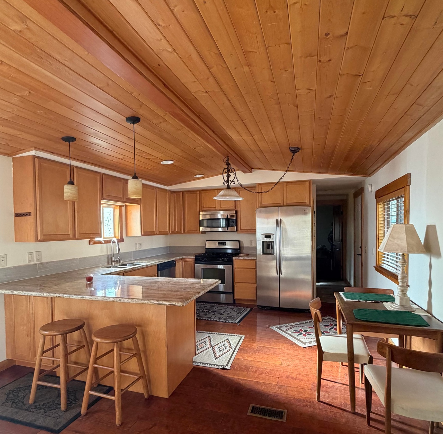 11070 Brockway Road, Unit 75 Truckee, CA 96161 - Photo 7 of 15 a kitchen with stainless steel appliances kitchen island granite countertop a table chairs in it and wooden floors