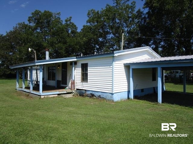 20705 Greek Cemetery Road Robertsdale, AL 36567 - Photo 5 of 25 Rear view of house featuring a yard, a metal roof, crawl space, covered porch, and a carport