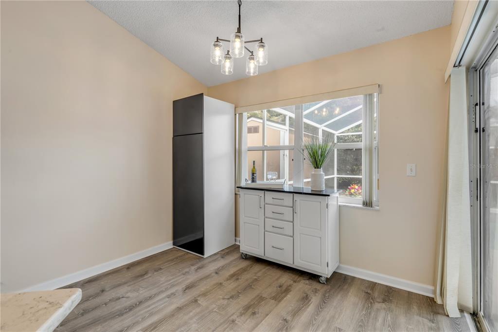 12232 Bronson Way Orlando, FL 32824 - Photo 12 of 32 an empty room with wooden floor cabinet and windows