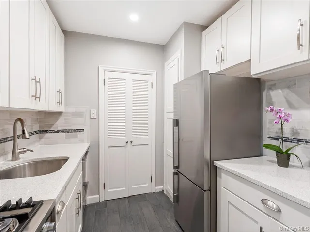 a view of a hallway with wooden floor and cabinet