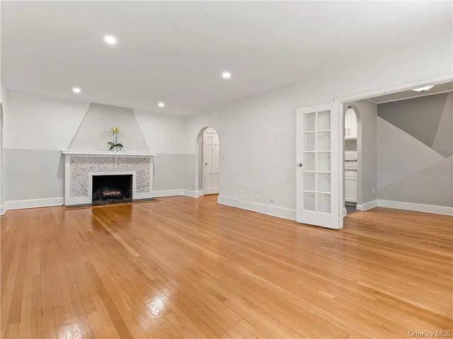 a view of empty room with wooden floor and fireplace