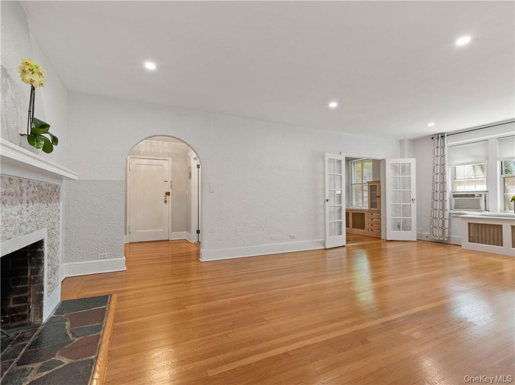 270 Bronxville Road, Unit B43 Bronxville, NY 10708 - Photo 7 of 36 an empty room with wooden floor and fireplace