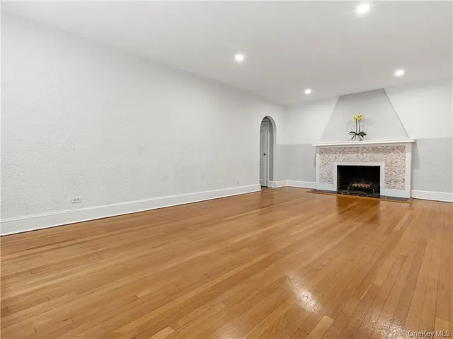 an empty room with wooden floor and fireplace