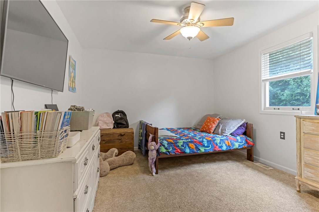 404 Davis Road Liberty, SC 29657 - Photo 18 of 39 Comfortable bedroom with neutral carpeting and a window overlooking lush greenery.