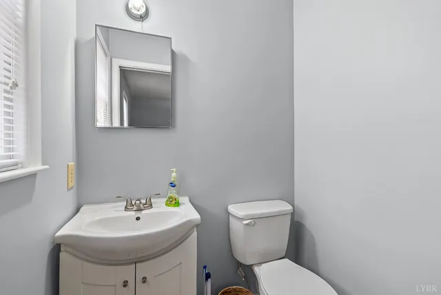 a bathroom with a sink toilet and a mirror