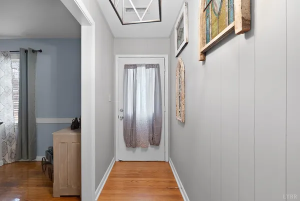 a view of a hallway with wooden floor and staircase