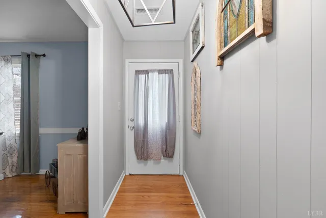 a view of a hallway with wooden floor and staircase