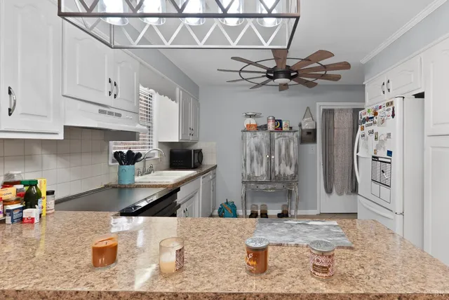 a kitchen with stainless steel appliances granite countertop a sink a stove and refrigerator