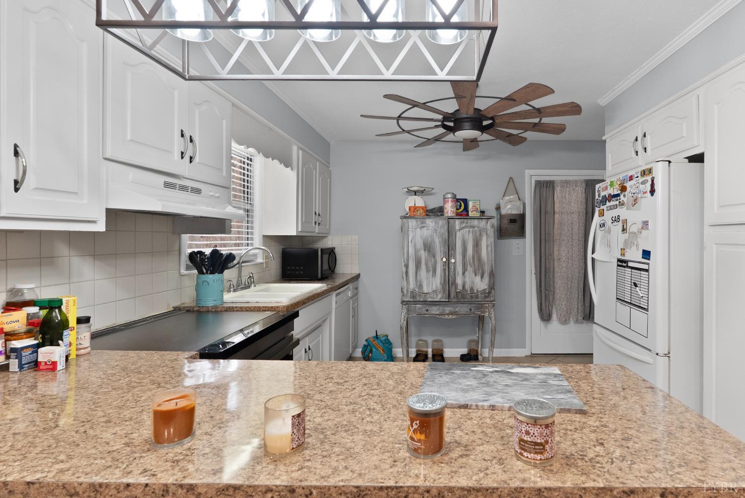 969 Hawkins Road Evington, VA 24550 - Photo 7 of 40 a kitchen with stainless steel appliances granite countertop a sink a stove and refrigerator