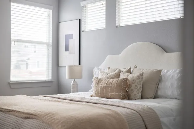 a large bed sitting in a bedroom next to a window