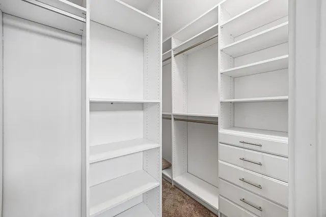 a view of walk in closet with empty racks