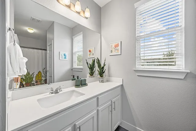 a bathroom with a sink a mirror and a window