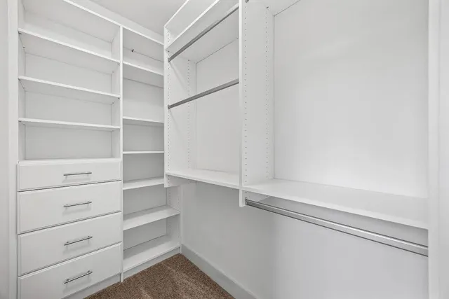 a view of walk in closet with empty racks