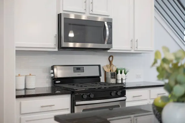 a kitchen with stainless steel appliances granite countertop a stove and a microwave