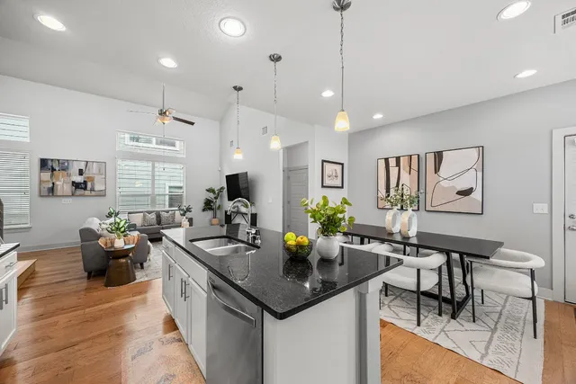 a kitchen with stainless steel appliances granite countertop sink stove and wooden floor