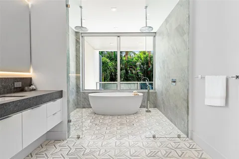 a bathroom with a double vanity sink a mirror and a bathtub