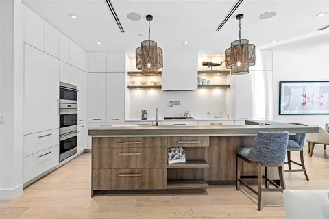 a kitchen with stainless steel appliances granite countertop a sink a stove and a wooden floors