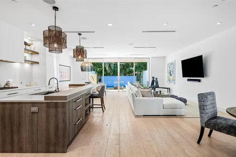 a living room with furniture a flat screen tv and kitchen view