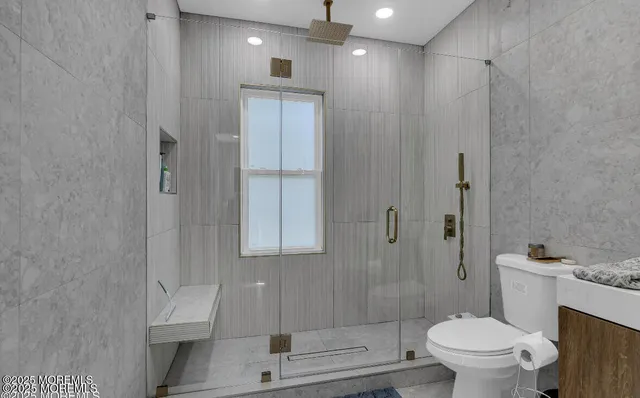 a bedroom with bed and a flat tv screen on dresser