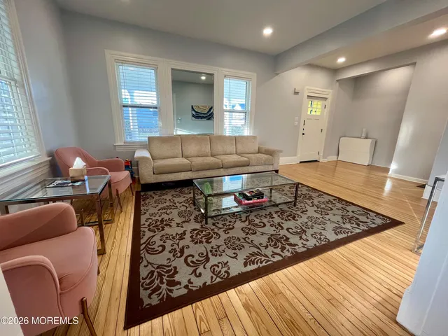 a living room with furniture and a wooden floor