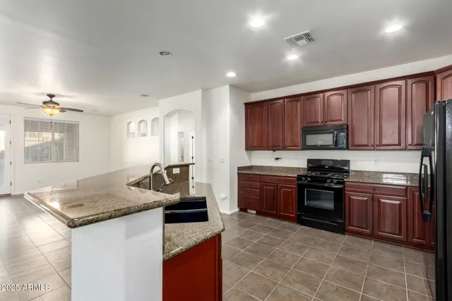 a view of kitchen with stainless steel appliances granite countertop a refrigerator a sink and a oven