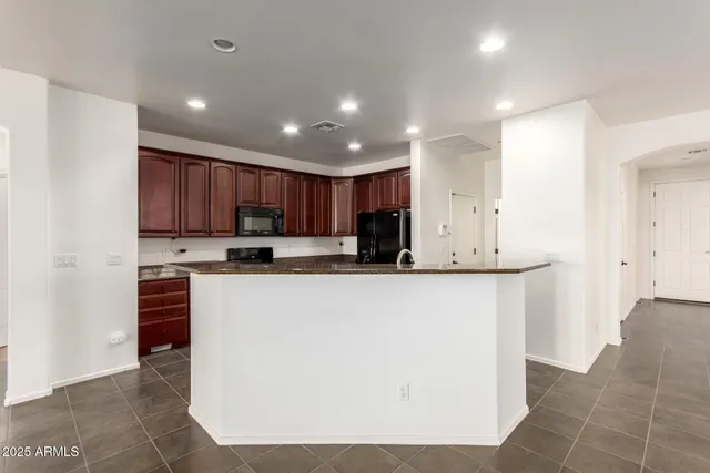 a kitchen with stainless steel appliances granite countertop a refrigerator a stove a sink and a microwave