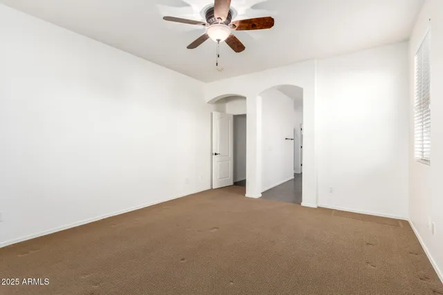 wooden floor in an empty room and a ceiling fan