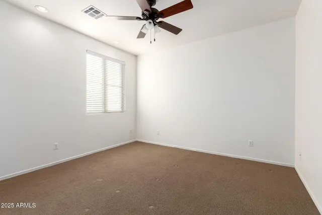 an empty room with chandelier fan