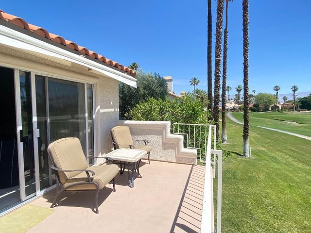 a balcony with wooden floor and outdoor seating