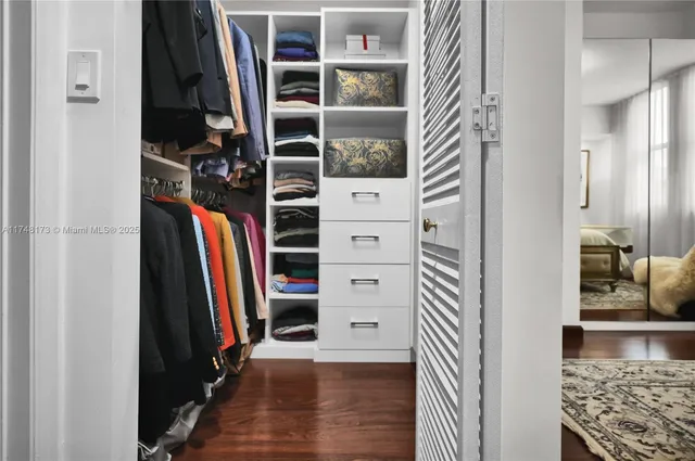 a view of walk in closet with clothes and shoes
