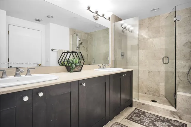 a bathroom with a double vanity sink mirror and shower