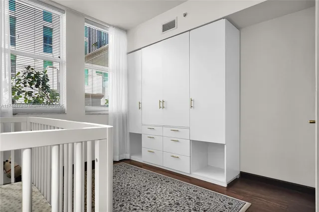 a view of a kitchen with white cabinets and wooden floor
