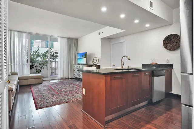 a living room with granite countertop wooden floor a couch and a potted plant