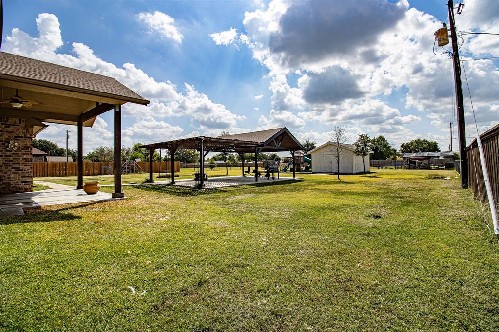 328 Meadow Lane Red Oak, TX 75154 - Photo 32 of 35 Fenced backyard featuring a patio area, a ceiling fan, and an outbuilding