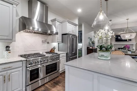 a kitchen with kitchen island stainless steel appliances a sink stove and refrigerator
