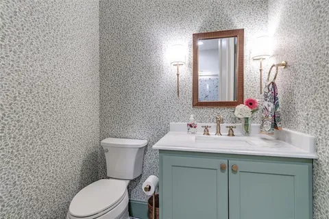 a bathroom with a toilet sink and mirror