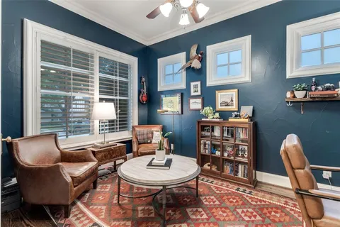a living room with furniture a bookshelf and a window
